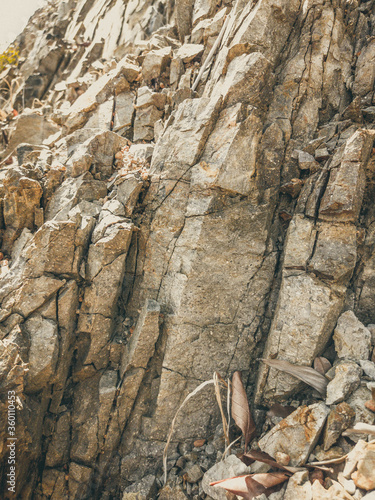 Natural background. Closeup edged shabby cliff cracks. Gray-brown stone rock texture of mountains. Vintage and faded matt style colour in tinted photo. Concept of geolog, mountaineering or hard work photo