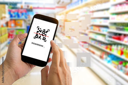 Man use smartphone scanning QR code for pay in supermarket.