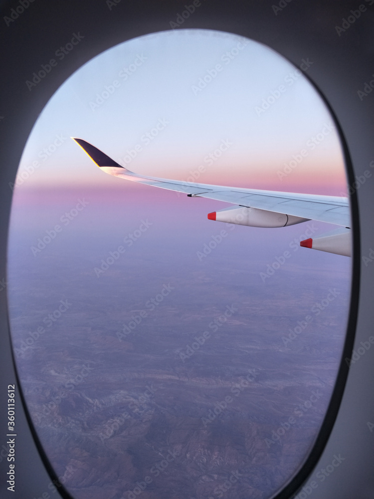 vertical photo for book magazine cover - airplane window frame with wing on the vanilla sky and show mountain on the ground vertical photo for book magazine cover - airplane window frame with wing on the vanilla sky and show mountain on the ground