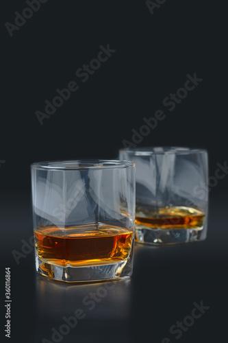 glass of pure scotch whiskey on black background
