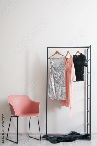 Wallpaper Mural Stylish armchair and hanger with female clothes near light wall Torontodigital.ca