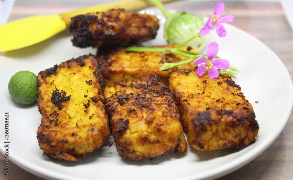 Fried tempe is a typical food from Indonesia.Tempe is made from soybeans.Tempe on a white plate Fried tempe is a typical food from Indonesia.Tempe is made from soybeans.Tempe on a white plate