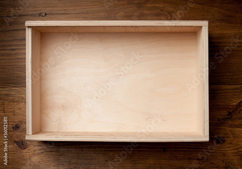 Empty wooden box on brown background.
