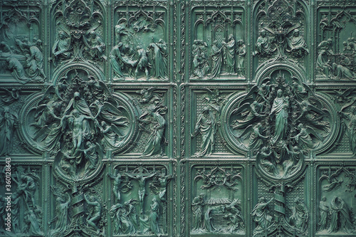 Main bronze door of the Milan Cathedral (Duomo di Milano) designed by Italian sculptor Ludovico Pogliaghi in Milan, Italy