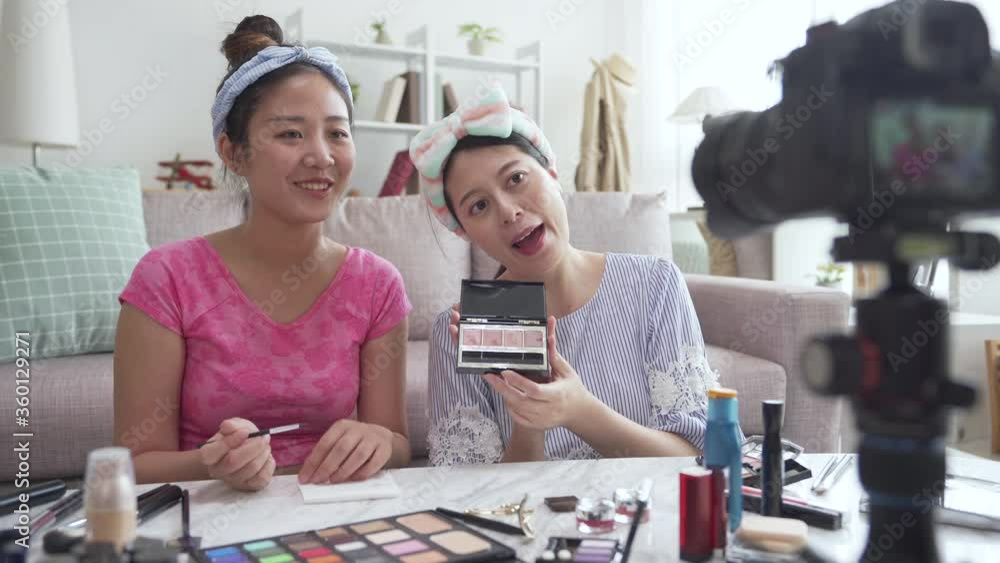 two young Asian cute artist women beauty vloggers doing cosmetic makeup