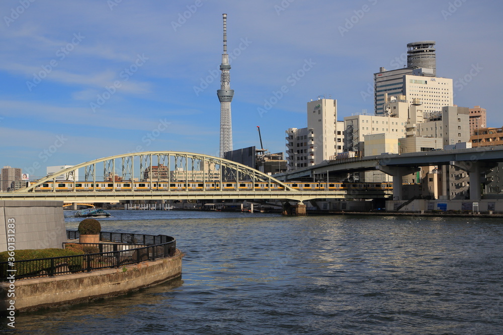 鉄橋を渡る総武線の電車と隅田川の風景