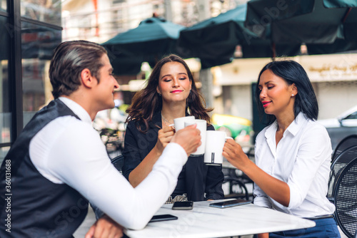Group of cheerful young friend discussing meeting and talk enjoying their time drinking coffee together.Mixed race people sitting at cafe table and restaurant