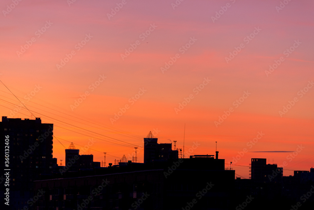Pink orange purple sunset over the city. Multicolored sky and black silhouette tall buildings of the metropolis