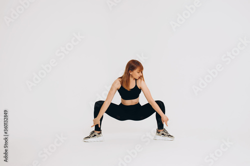 Beautiful young girl doing yoga or pilates exercise isolated on white background. Concept of healthy life and natural balance between body and mental development. Full length