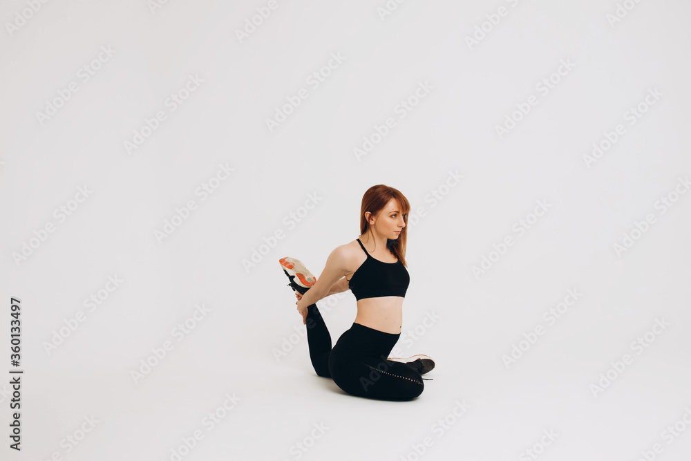 Fit girl warming up. Full length of young african girl in sportswear stretching her arms on white background. Stretching and motivation