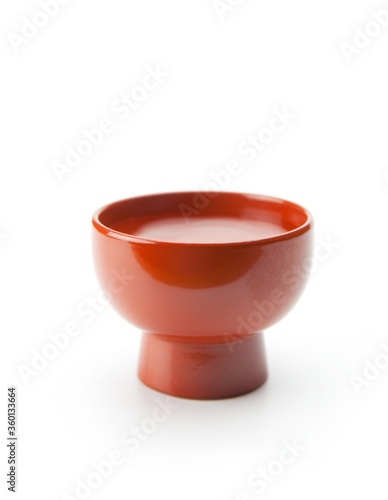 Sake (Liquor made from rice) served in a traditional enameled ochoko cup, isolated on white. photo