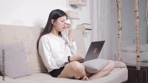 The beautiful woman sitting on the sofa cried while using the computer. photo