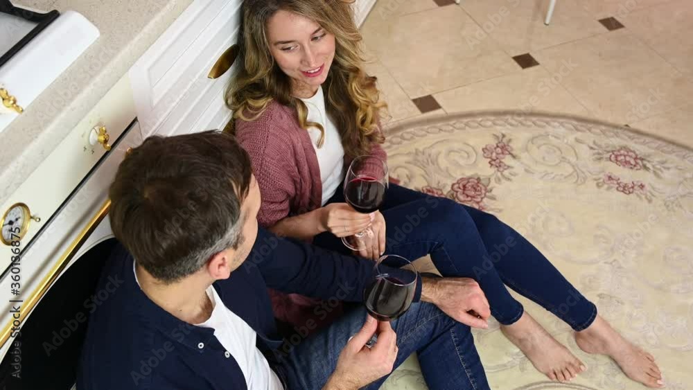 Happy woman and man drinking red wine at the kitchen Happy woman and man drinking red wine at the kitchen