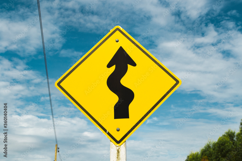 Curve road warning sign on blue sky background. Curve road warning sign on blue sky background.
