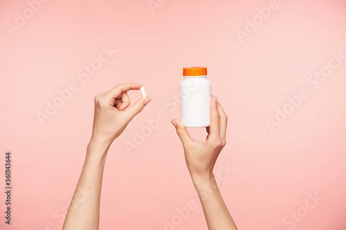 Foto Cropped photo of raised female's well-groomed hands holding white pill and bottl