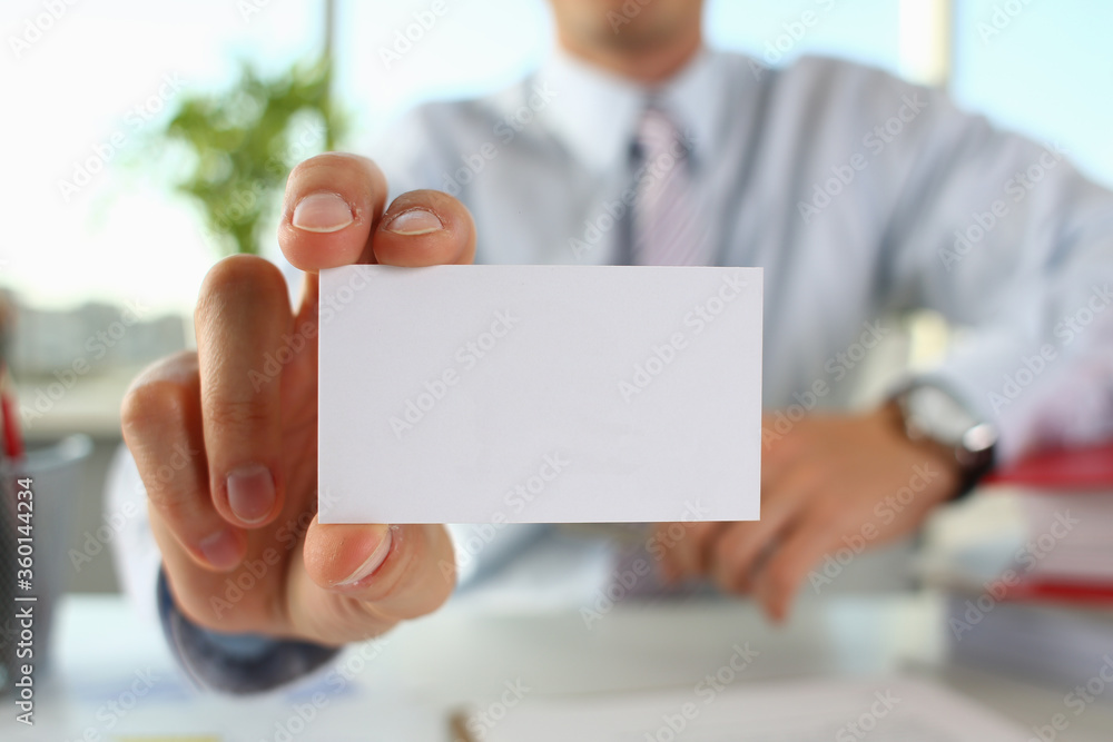 Close up of male hand holding business card with telephone and e-mail address Close up of male hand holding business card with telephone and e-mail address