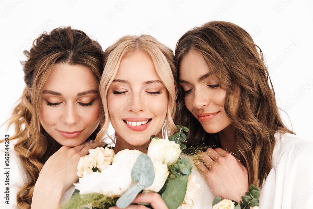 Photo of smiling bride with her bridesmaids posing with flowers Photo of smiling bride with her bridesmaids posing with flowers