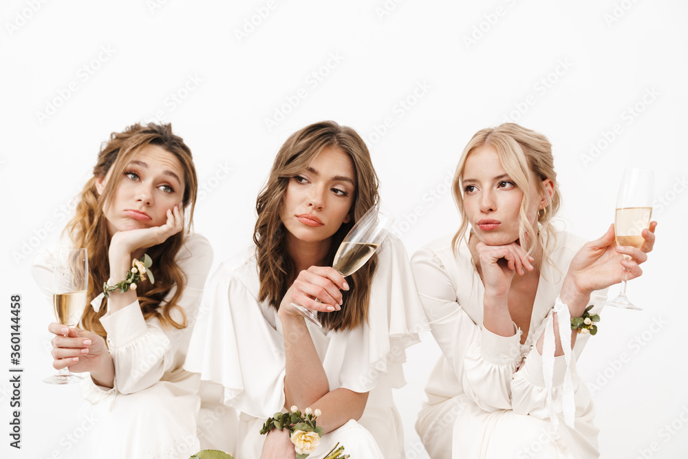 Photo of tired beautiful bridesmaids sitting and drinking champagne Photo of tired beautiful bridesmaids sitting and drinking champagne