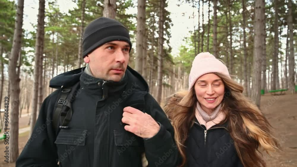 Man and woman having fun with backpacks in the forest Man and woman having fun with backpacks in the forest