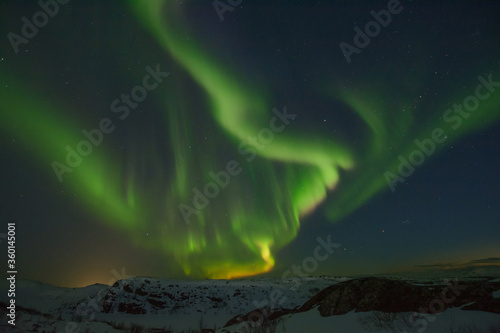 Northern lights over tundra and rocks. © Moroshka