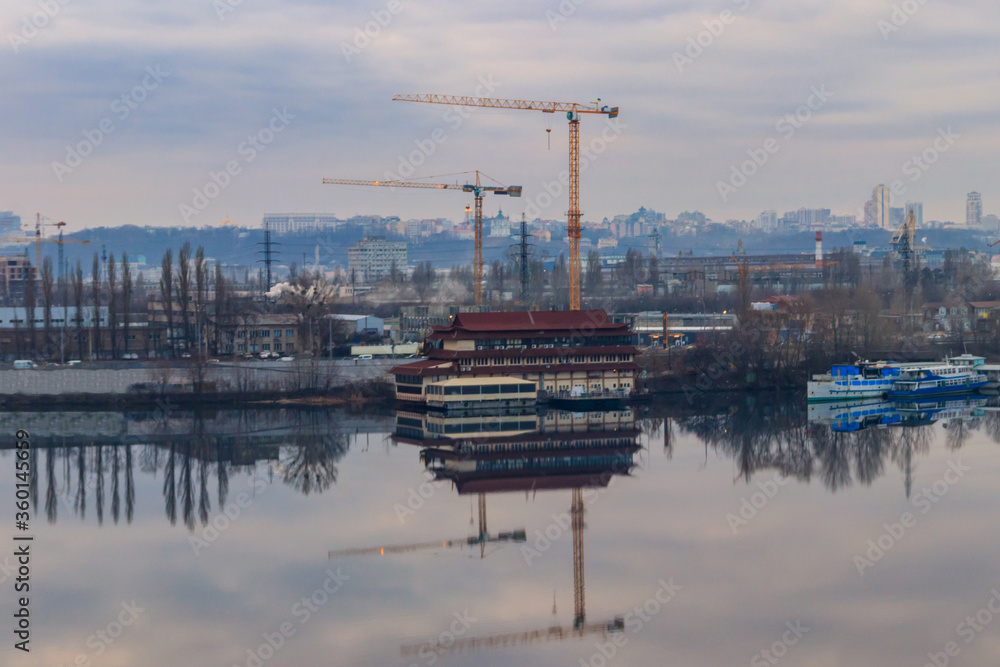View of the Dnieper river and construction cranes on right bank in Kiev, Ukraine View of the Dnieper river and construction cranes on right bank in Kiev, Ukraine