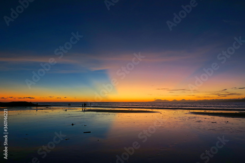 Kuta beach sunset lans sun rays in blue sky, Bali island, Indonesia