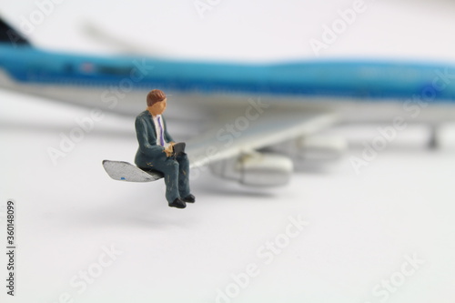 kleines Flugzeugmodell mit eine Figur eines Geschäftsmannes 