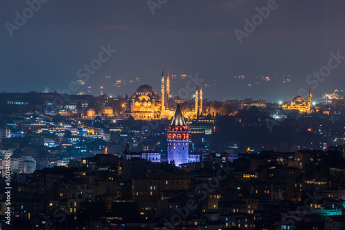 Galata Tower and Suleymaniye Mosque at night in Istanbul, Turkey.