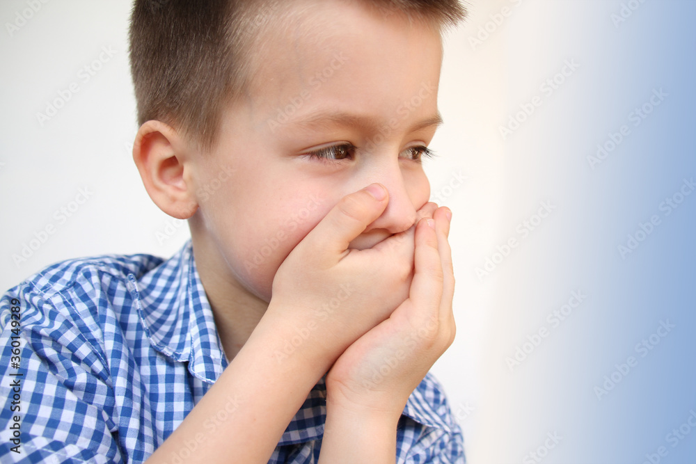 boy, kid, covered his mouth with his palms, so as not to say anything superfluous, concept of upbringing, education, speech behavior, emotional development of children, obscene language boy, kid, covered his mouth with his palms, so as not to say anything superfluous, concept of upbringing, education, speech behavior, emotional development of children, obscene language