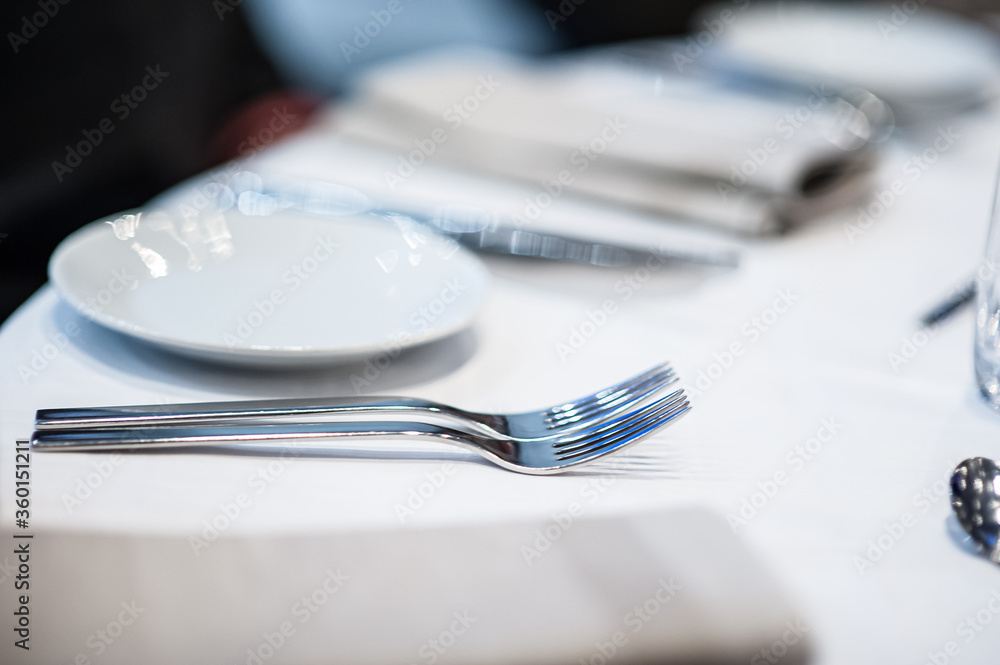 Cutlery and plate on a table in a restaurant. Cutlery and plate on a table in a restaurant.