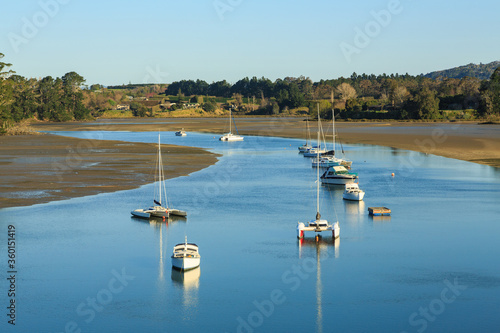 Recreational boats in a harbor channel at low tide. Photographed in New Zealand