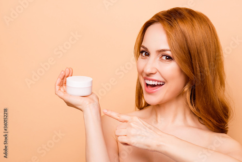 Fototapeta Naklejka Na Ścianę i Meble -  Close-up portrait of her she nice-looking attractive cheerful wavy-haired lady holding in hand showing new novelty daily day cool effective useful cream bottle protein isolated over beige background