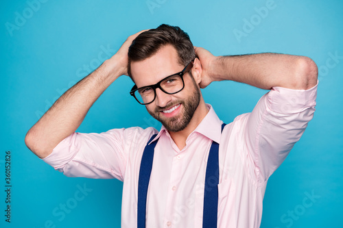 Photo of handsome business man beaming smile hold arms on head check neat hairdo salon styling groomed appearance wear specs pink shirt suspenders isolated blue color background