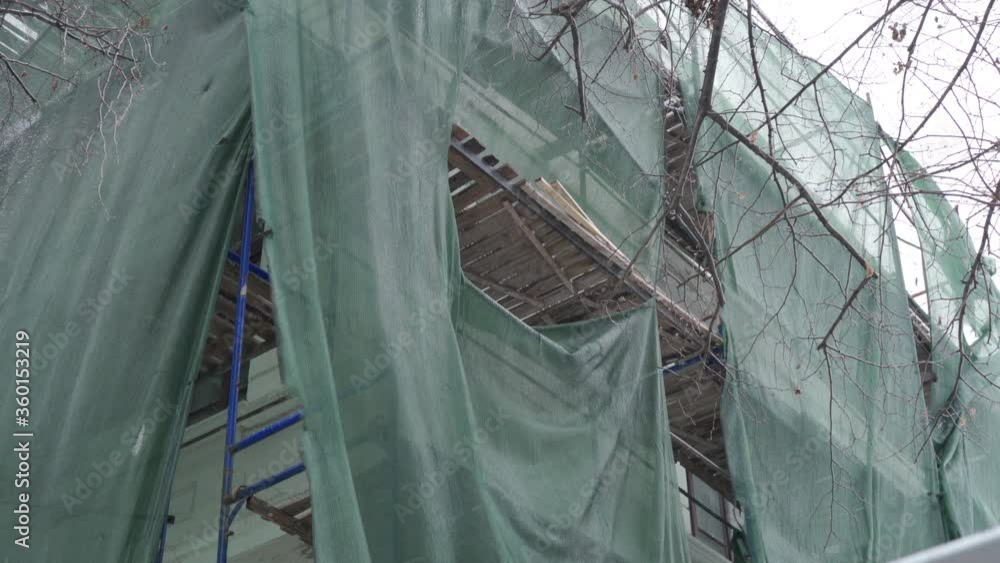 Old building facade renovation with scaffolding system in front of