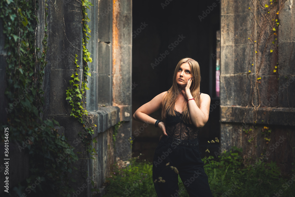 Fototapeta premium Young girl posing in old ruins.