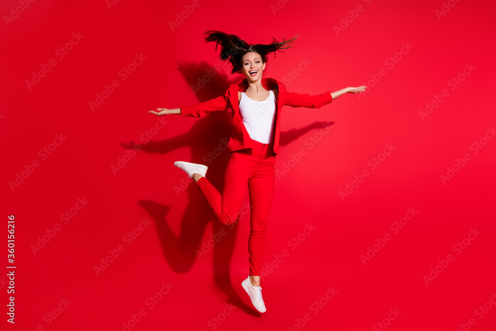 Full length photo of attractive worker lady having fun jumping high up good mood rejoicing vacation time wear blazer suit pants footwear isolated bright red color background