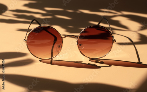 Brown sunglasses in a round shape. Bright sunlight.