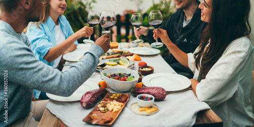 Multi ethnic Group of people dining out smiling and laughing, Friends sitting at the dinner table talking and planning to go on summer vacation together in a car with tents, Friendship Celebration photo