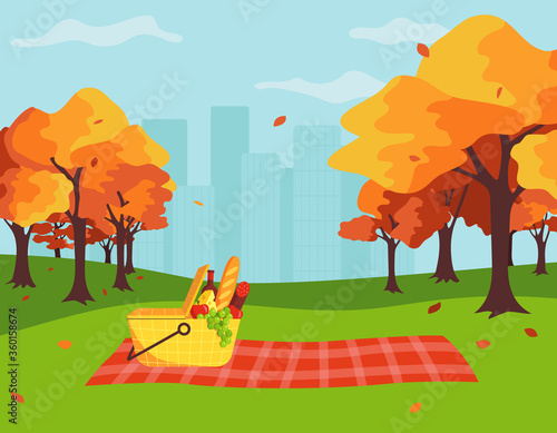 A picnic concept in a city park in the fall. Basket and picnic blanket on the background of autumn trees and the city. Cartoon vector illustration in flat style.