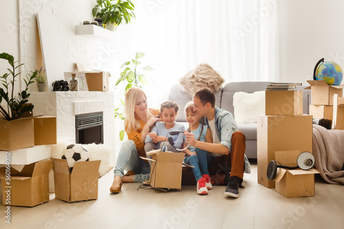 Happy family with cardboard boxes in new house at moving day. © Angelov
