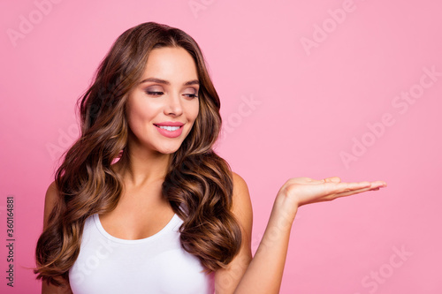 Photo of pretty cute wavy lady sales manager holding new discount price product open palm hand cool offer wear white casual tank-top isolated pink color background