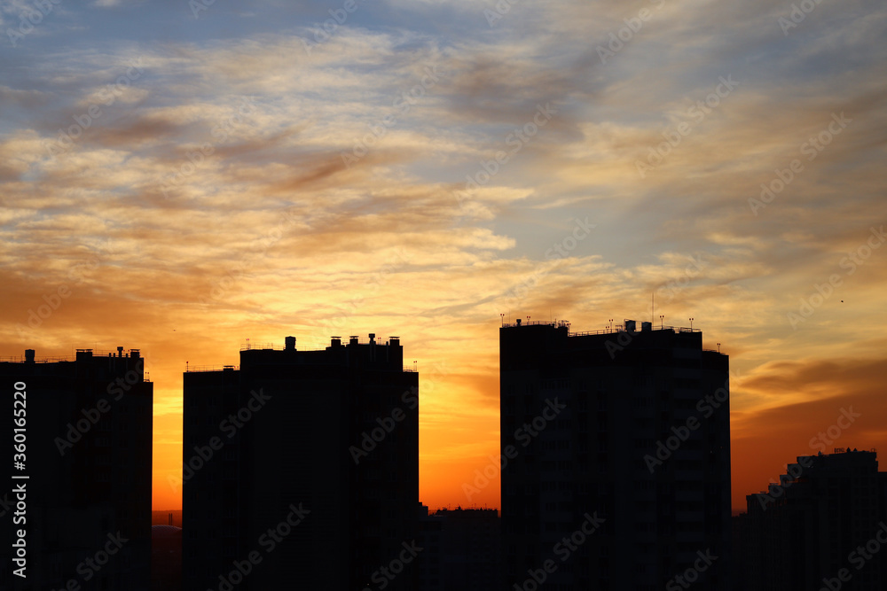 Sunset in a big city, the shadow of high-rise buildings on a sunset background, evening Kiev, the capital of Ukraine