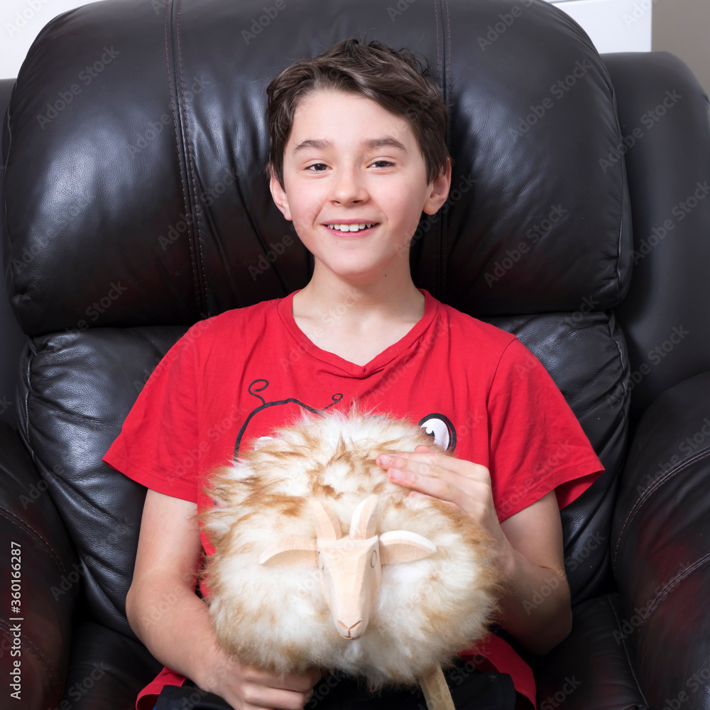Teenage boy in own room with sheep. Funny face.