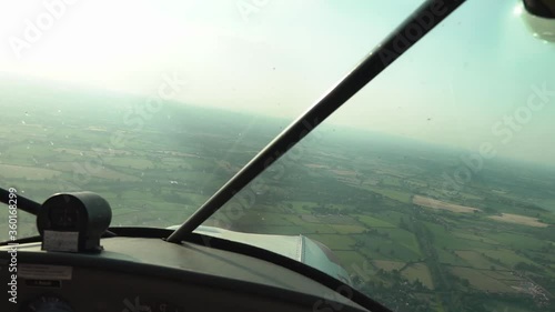 Point of view shot from inside a small single engine plane as it flies over the countryside