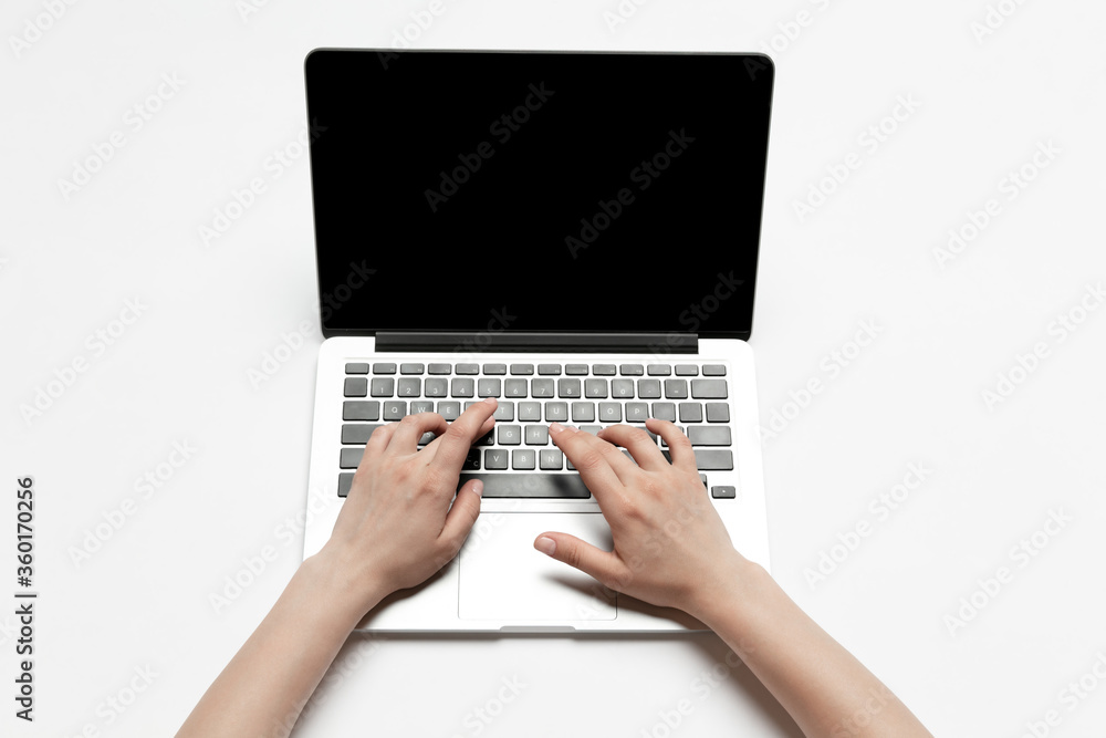 Close up of human hands using laptop isolated on white background. Top view. Copyspace, blank screen. Surfing, online shopping, scrolling, betting, working. Education and business concept. Close up of human hands using laptop isolated on white background. Top view. Copyspace, blank screen. Surfing, online shopping, scrolling, betting, working. Education and business concept.