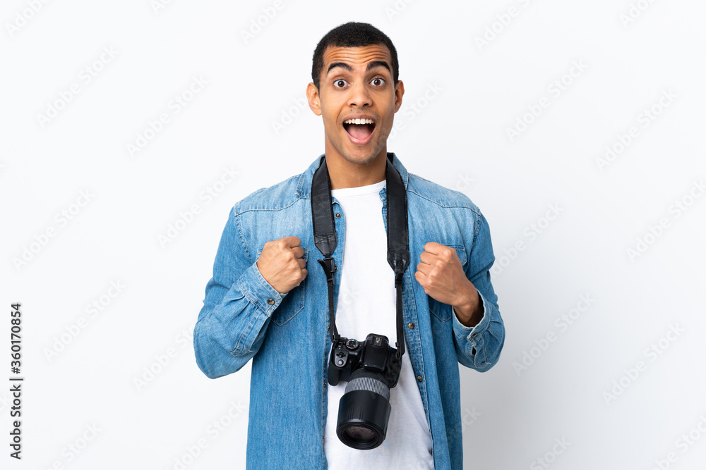 Young African American photographer man over isolated white background celebrating a victory Young African American photographer man over isolated white background celebrating a victory