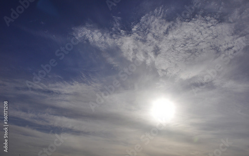 Panorama of the sunny sky. The sun in the haze of cirrostratus clouds. Signs of weather changes in the Western Urals.
