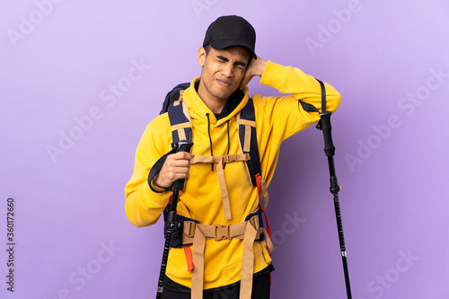 African American man with backpack and trekking poles over isolated background frustrated and covering ears © luismolinero