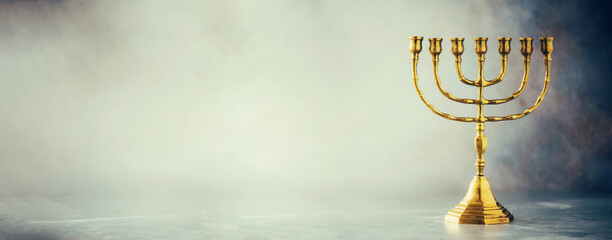 Golden hanukkah menorah on grey background. Jewish holiday banner with copy space. Ancient ritual religious candle menorah