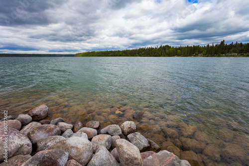 Rocky shore of Clear Lake in Wasagaming, Manitoba on a cloudy day photo